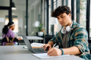 Student using laptop while wearing headphones