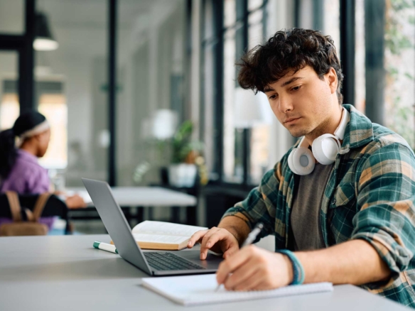 Student using laptop while wearing headphones